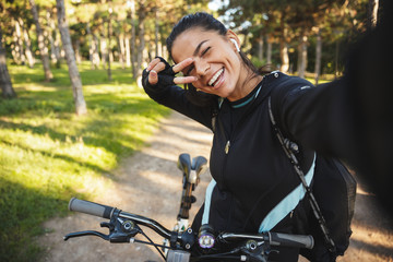 Attractive fit sportswoman riding on a bicycle at the park