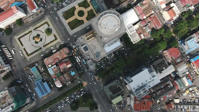 Aerial drone view looking down vertically at buildings and traffic in central Phnom Penh, Cambodia, Southeast Asia. Camera slowly flies forward
