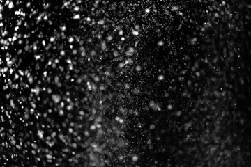 Falling snow on a black background. Snowfall weather. Texture for overlay
