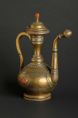 ancient oriental metal teapot on dark background. antique bronze tableware
