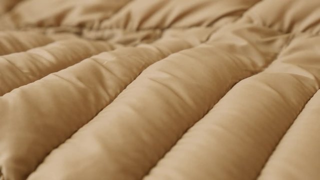 Puffer jacket ribs and fabric surface slow pan 4K video