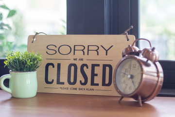 A sign hanging off Coffee shop door,Close sign blur background,Label word close