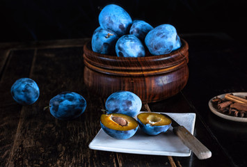 Blaue Zwetschgen auf dunklem Holztisch