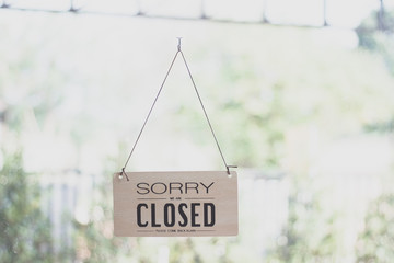 A sign hanging off Coffee shop door,Close sign blur background,Label word close