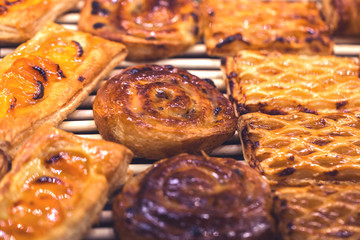 Mouthwatering Danish spiral cinnamon raisin rolls, golden and shiny on display, bakery and cafe concept, sweet indulgence