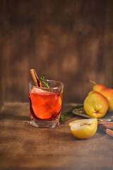 homemade hot mulled pear cider with a cinnamon stick on a wooden background
