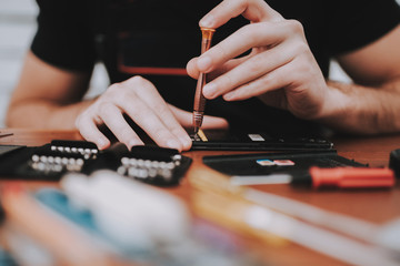 Close up Young Man Repairing Mobile Phone at Table