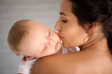 Young mother, holding tenderly her newborn baby boy
