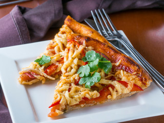 Two slices of pizza on white plate at restaurant table. Close up