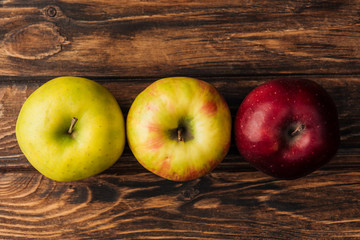 top view of row of ripe multicolored apples on wooden table