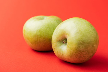 ripe large green apples on red background