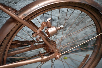 Partial view of a golden painted bicycle. A golden bicycle with a dynamo.