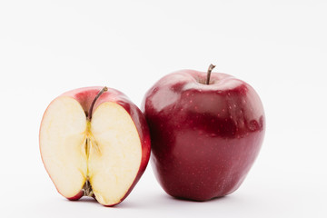 half and whole ripe red delicious apples on white background