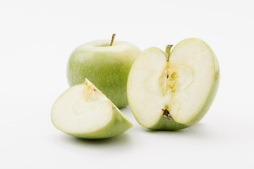 cut and whole delicious green apples on white background