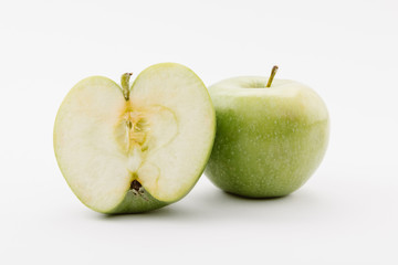 cut and whole ripe green apples on white background
