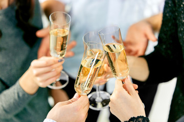 Celebration. Hands holding the glasses of champagne and wine making a toast. The party, alcohol, lifestyle, friendship, holiday, christmas, new, year and clinking concept