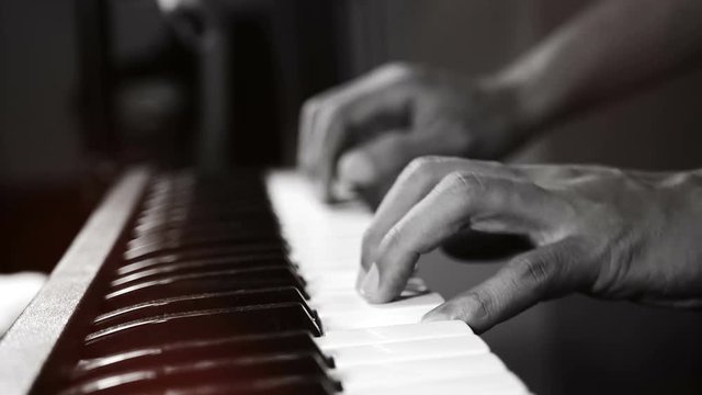 4K footage of music pianist hands playing piano at the night club with spotlight and light leak bokeh. musical instrument grand piano selective focus with depth of field