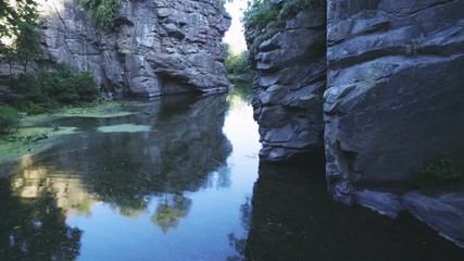 Wild brook flowing between several high rocks in the Carpathians in summer