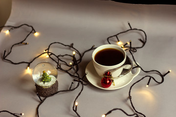 Obraz na płótnie Canvas Cup of coffee and a Christmas red ball. Christmas time