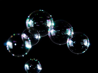 Fototapeta na wymiar Blurred soap bubbles on black background, Photo of soap bubble, soap bokeh background,