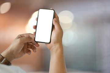 Closeup of male hand holding blank screen smartphone over blurred bokeh background