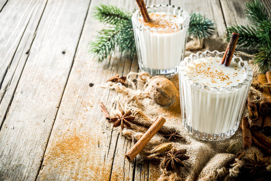 Classic Christmas drink Eggnog, chilean Cola de mono (monkey tail) cocktail, or Puerto Rican Coquito  eggnog, on old wooden background with pine tree branches copy spaces