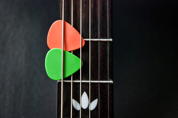 colorful guitar picks on fingerboard