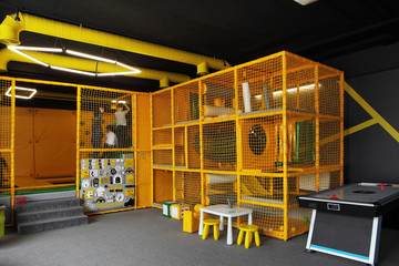 Children's playground with yellow grid and trampoline and air hockey near.Children playground - Powered by Adobe