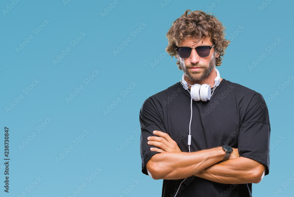 Sticker handsome hispanic man listening to music wearing headphones over isolated background skeptic and ner