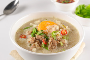 Congee with minced pork and boiled egg in bowl