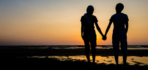 Fototapeta na wymiar Asian of couple Lesbian romantic clap hand on the beach Sunset background Summer honeymoon vacation and holidays shoot photo by smart phone