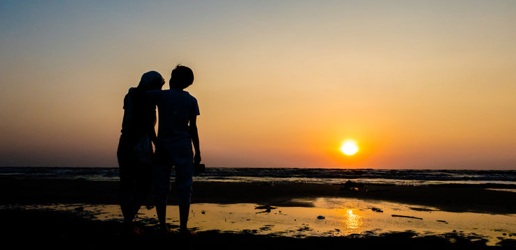 Asian of couple Lesbian romantic hugging on the beach Sunset background Summer honeymoon vacation and holidays shoot photo by smart phone