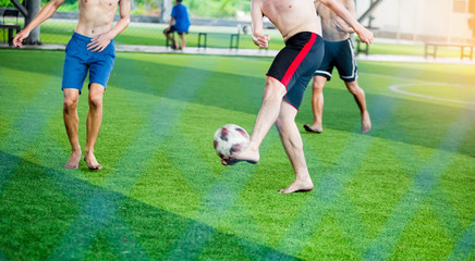 Soccer players not wearing a sport shirt and barefoot do trap and control the ball for shoot to goal