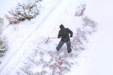 Workers sweep snow from road in winter