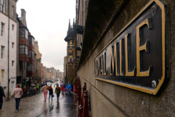 Fototapeta premium Edinburgh, Scotland / United Kingdom - August 2014: Royal Mile sign in the foreground and the street unfocussed in the background