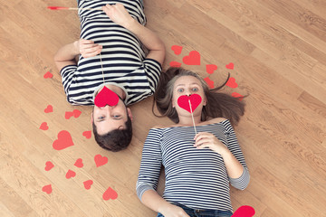 Top view young couple lying on the floor and looking to camera.