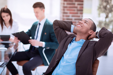 dreaming businessman on blurred background office. photo with copy space