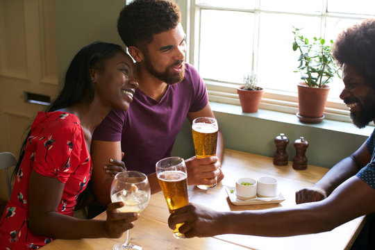 Young Couple Drinking With An Older Man In A Pub