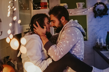 Couple hugging in the kitchen on Christmas eve