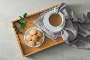 Closeup of coffee with milk in white cup and tasty cookies. Shot on light stone background