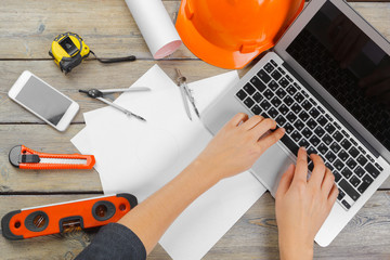 Architect workplace with open laptop and instruments top view