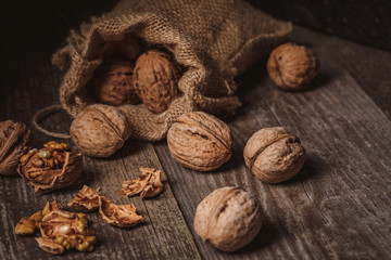 close up view of walnuts in sack on wooden background