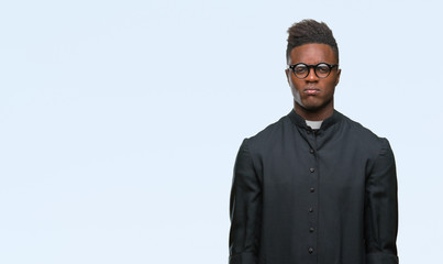 Young african american priest man over isolated background skeptic and nervous, frowning upset...