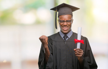 Young graduated african american man holding degree over isolated background screaming proud and...