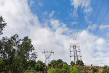 Electricity transmission towers against blue sky background. Horizontal color photography.