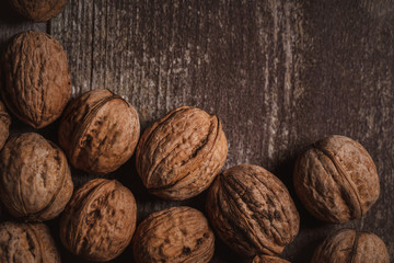 top view of walnuts arranged on wooden surface