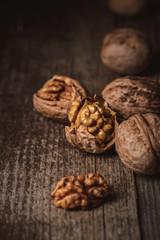 close up view of shelled and whole walnuts on wooden tabletop