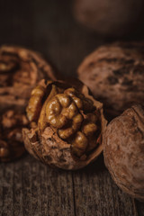 close up view of shelled and whole walnuts on wooden tabletop