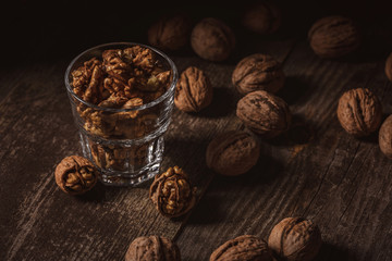 close up view of tasty shelled walnuts in glass on wooden table