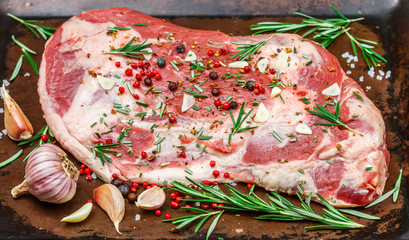 Fresh meat. Raw lamb shoulder ready for baking with garlic, rosemary, juniper, pepper and salt....